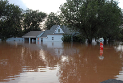 Flooded residential neighborhood with submerged stop sign during spring flooding