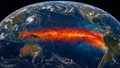 Satellite-style view of the equatorial Pacific showing a warm sea surface temperature anomaly plume stretching from Indonesia eastward to South America, depicting a developing super El Nino