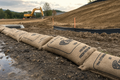 Hydrated burlap sandless sandbag linear barrier as perimeter sediment control on a construction site SWPPP setup